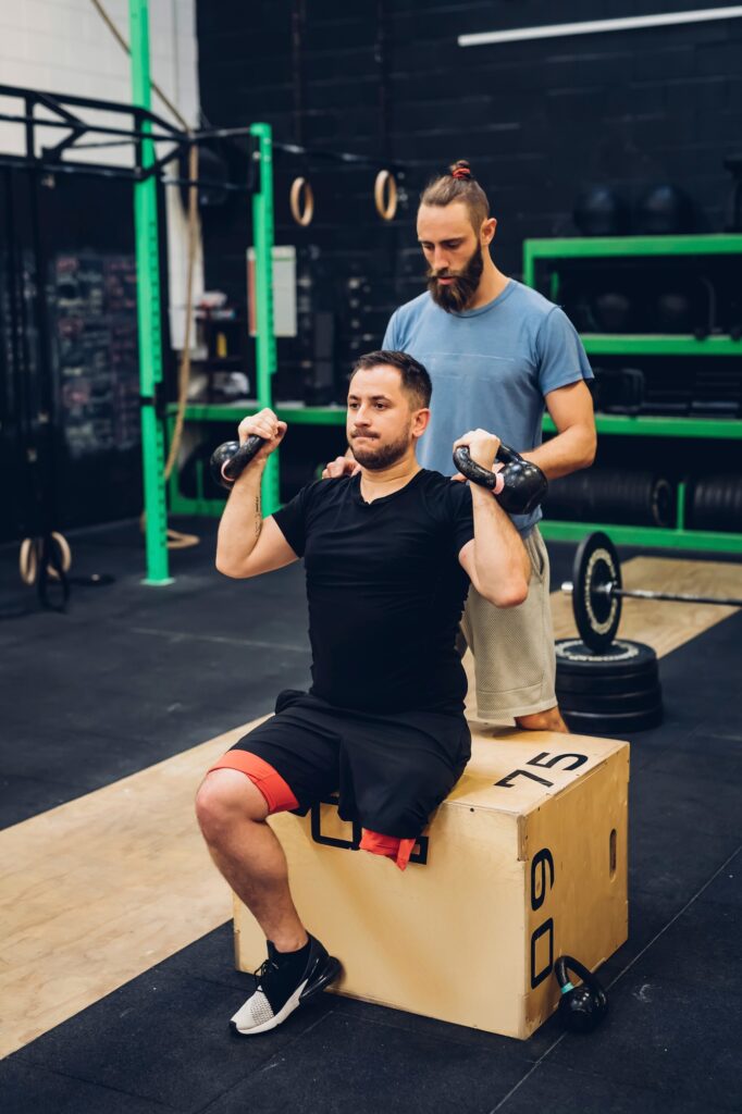 Man with disability using kettlebells with trainer